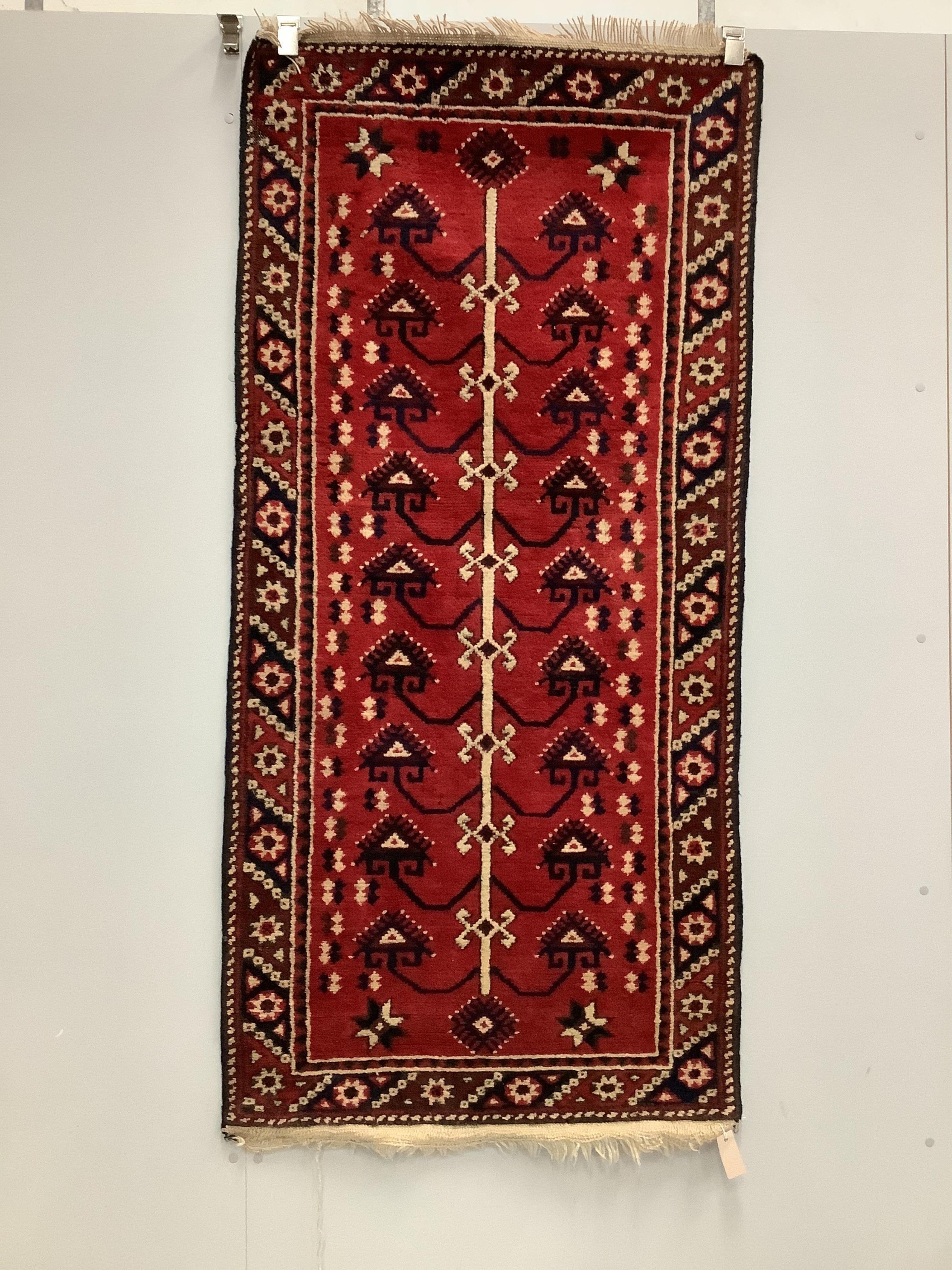 A Kazak style red ground rug, (moth damage) and a Turkish red ground rug, larger 200 x 98cm. Condition - poor to good